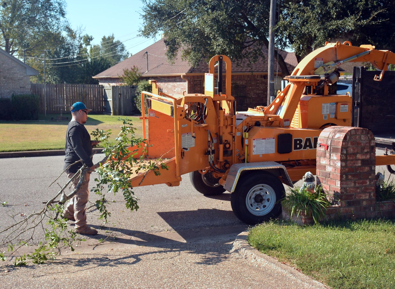 Ground crew working on a commercial site with a chipper